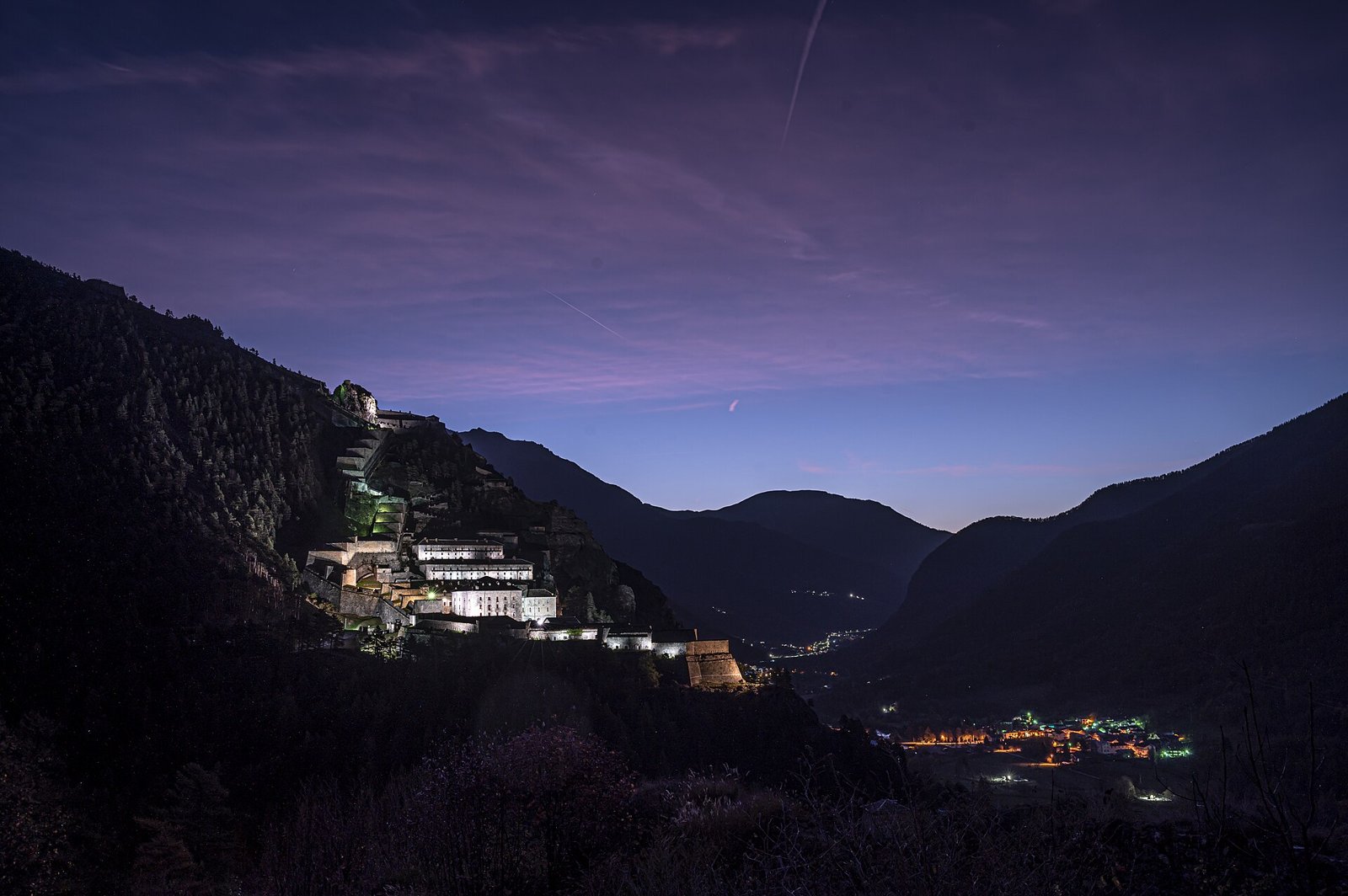 Il Forte di Fenestrelle illuminato al crepuscolo lungo il pendio della Val Chisone