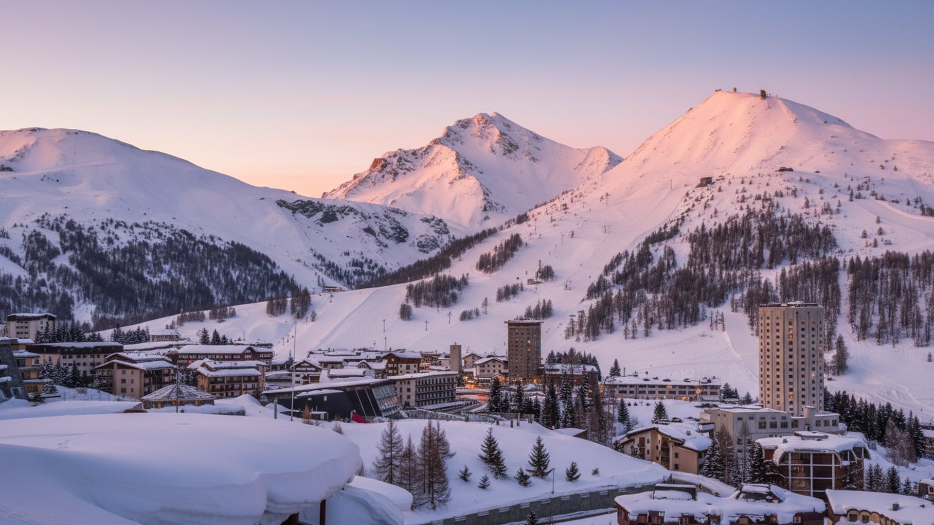 Sestriere innevata all'alba con le montagne della Vialattea